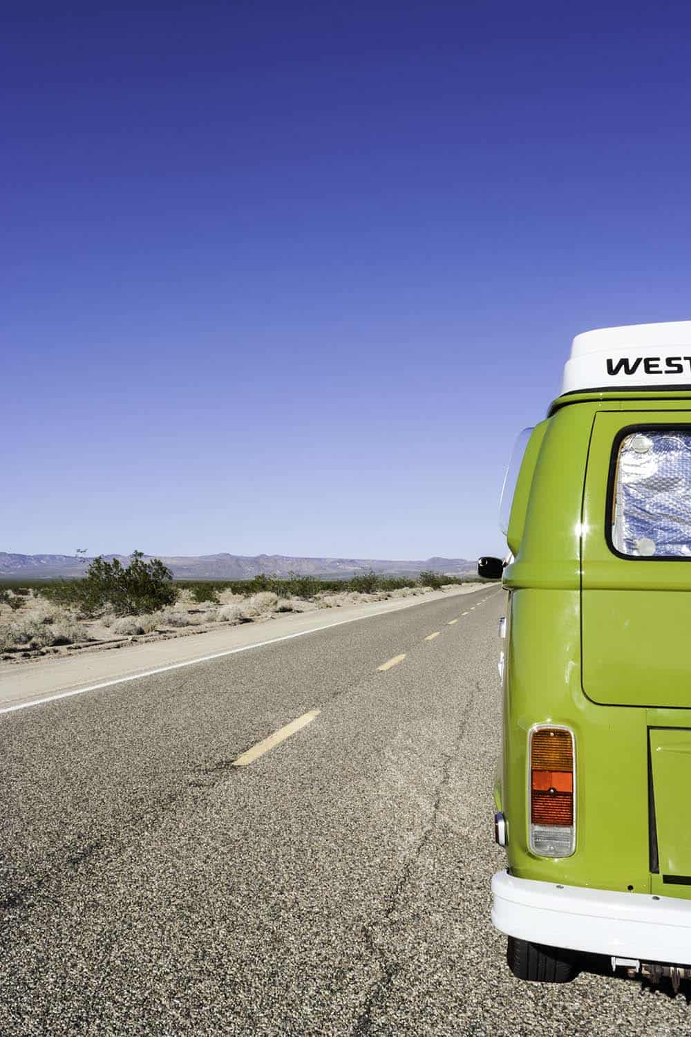 VW Bulli T2 auf Straße in Kalifornien mit Blick in Landschaft